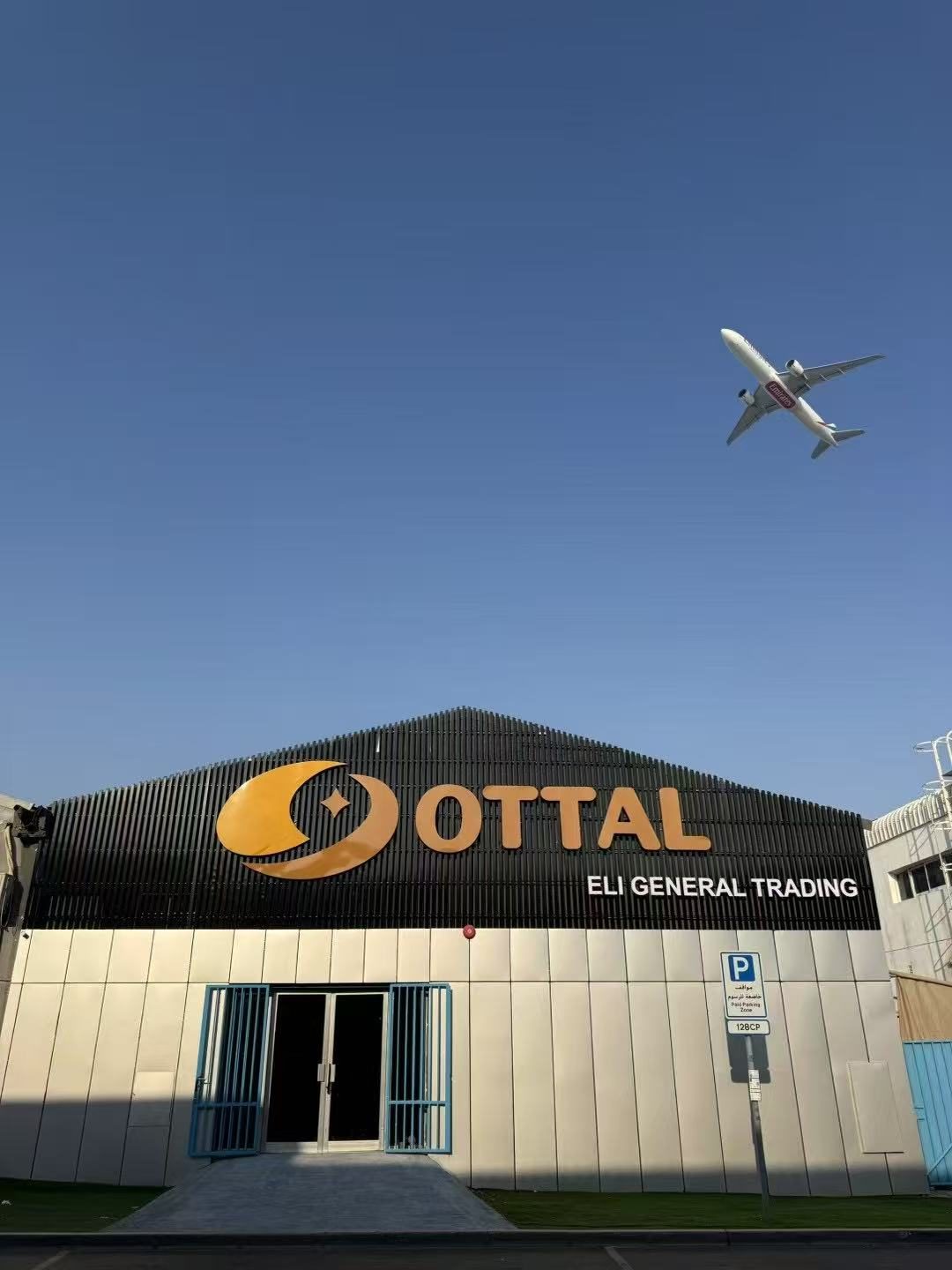 OTTAL branded headquarters in Dubai with Emirates aircraft overhead